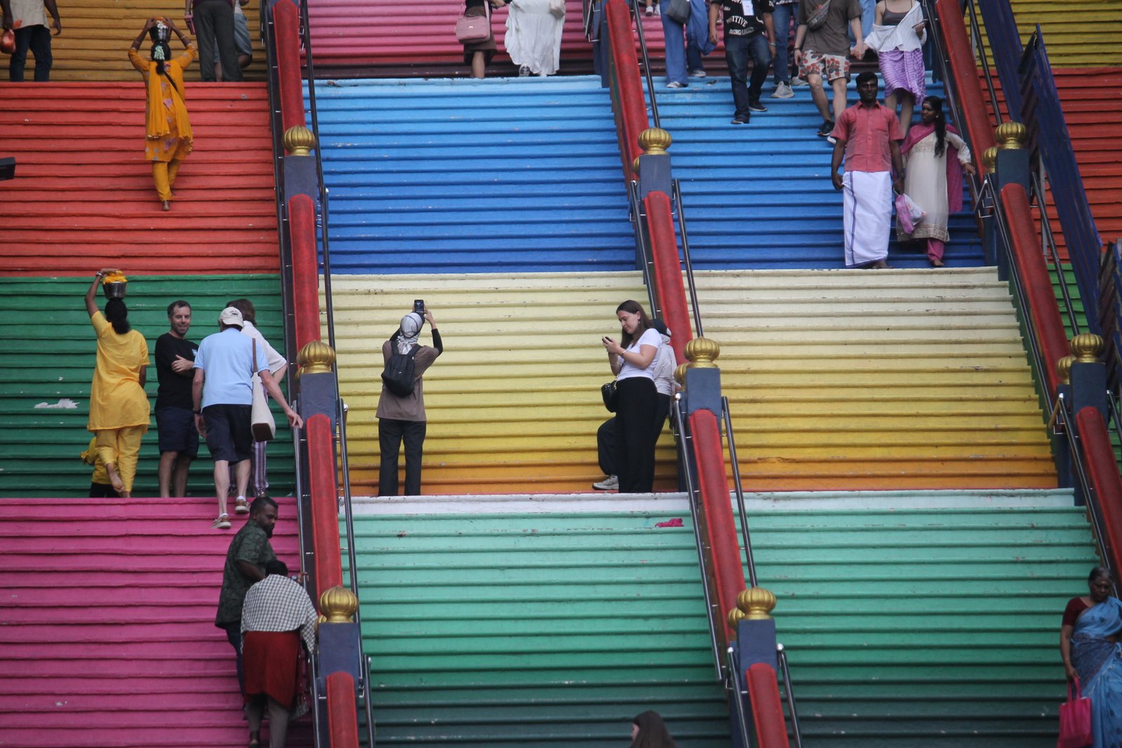 Visitors climbing the brightly coloured staircase at Batu Caves in Kuala Lumpur