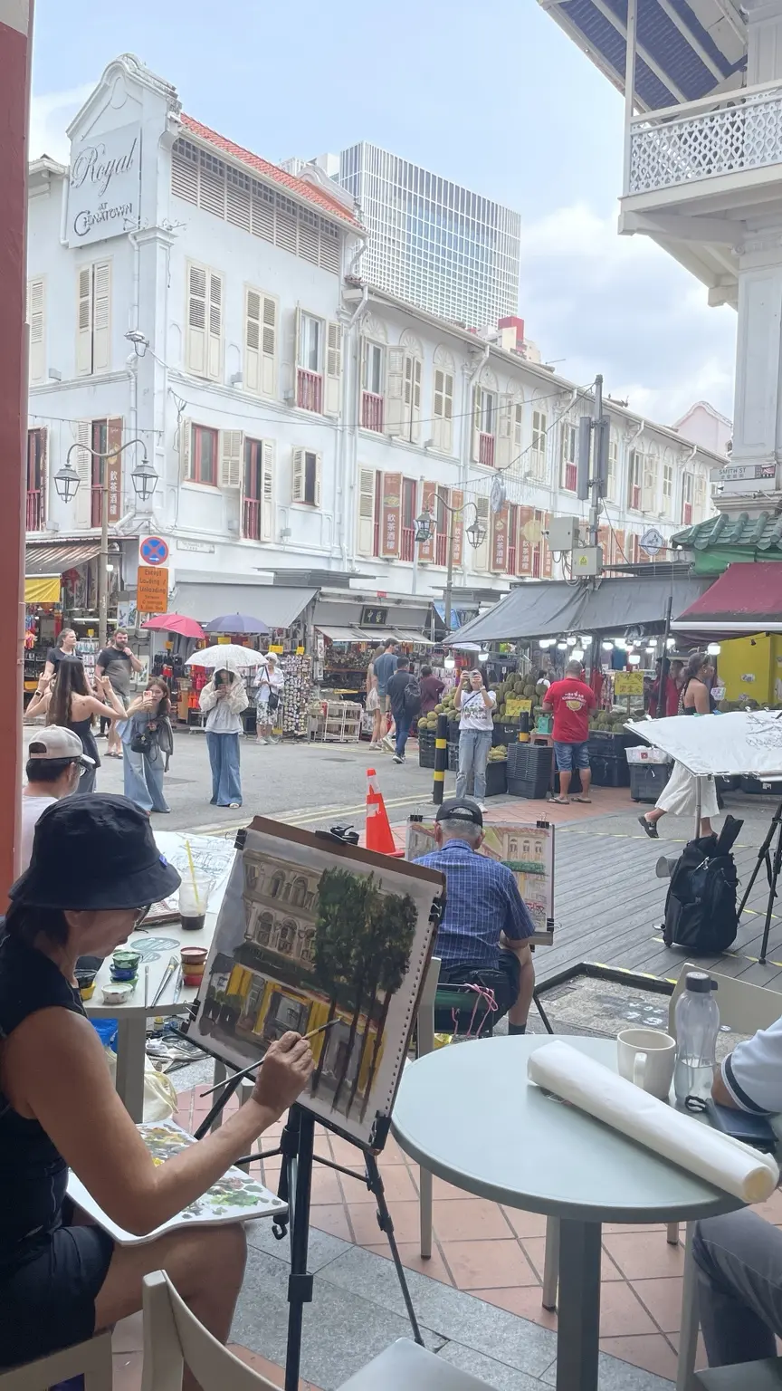A street artist painting among the historic houses of Chinatown in Singapore