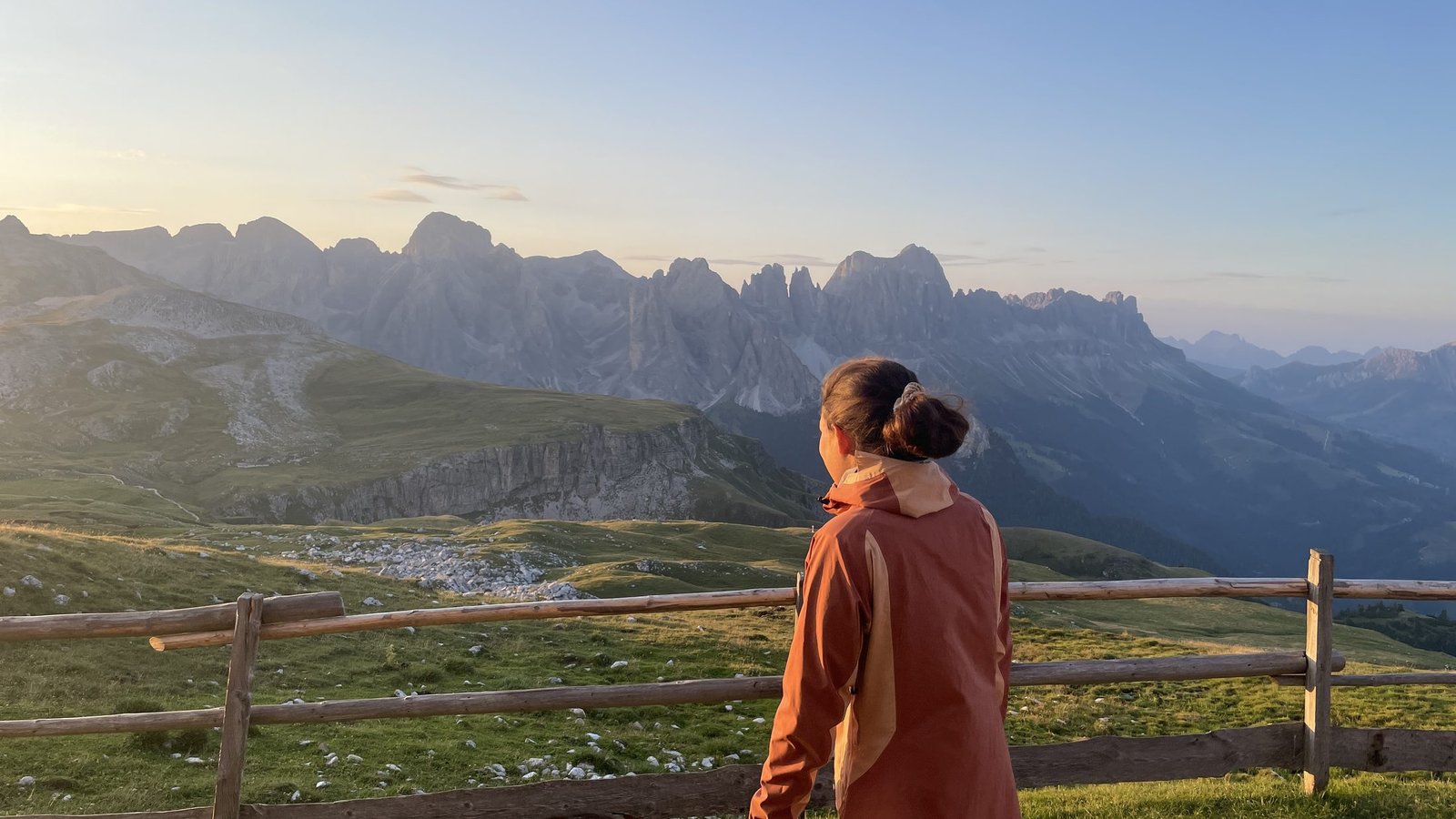 A hiker watching sunset from Schlernhaus in the Dolomites