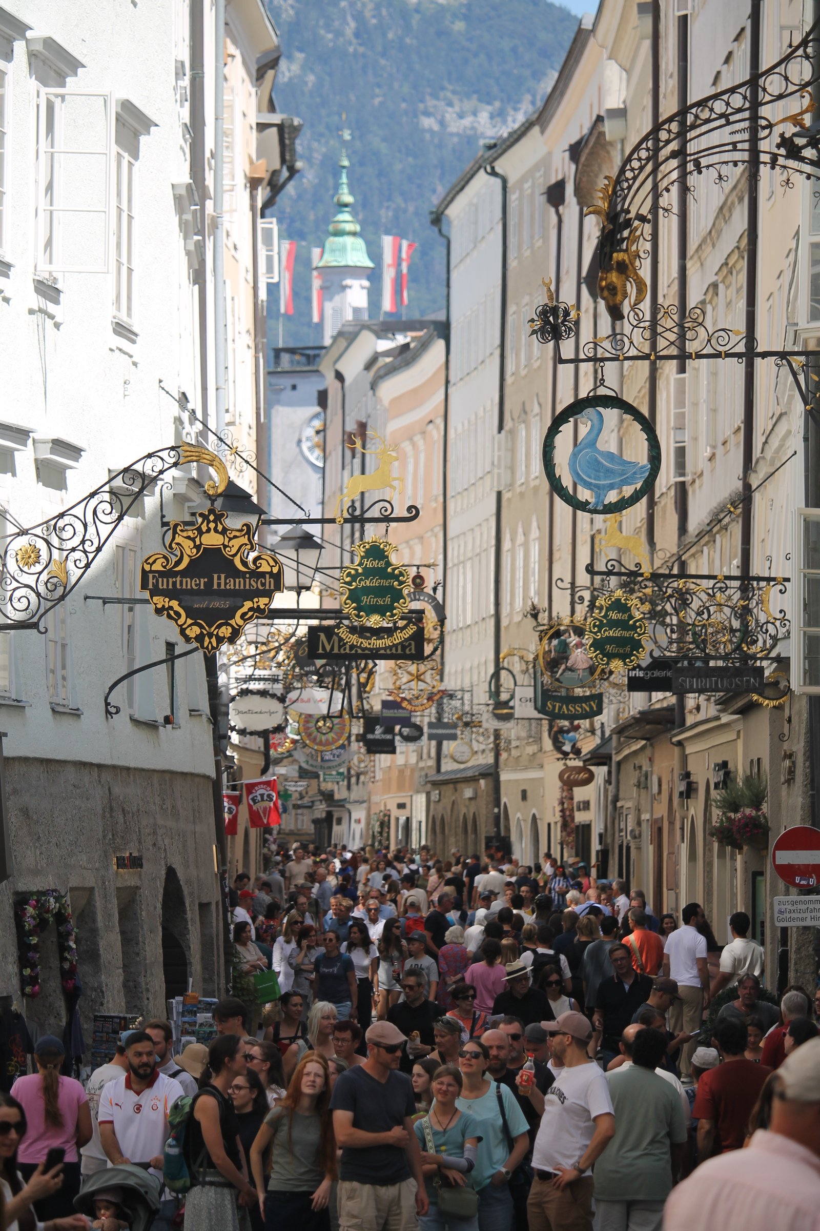 Busy Getreidegasse in Salzburg with historic wrought-iron signs